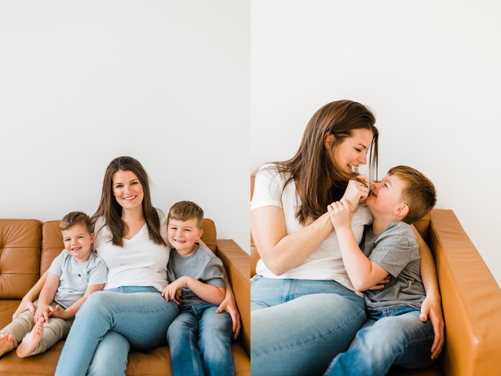 Female photographer snuggling her two young boys on a couch in a studio
