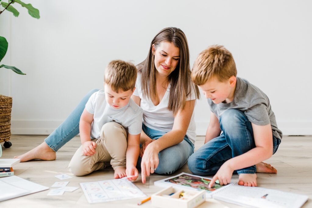 Photographer and her children on the floor of a studio doing a homeschool lesson