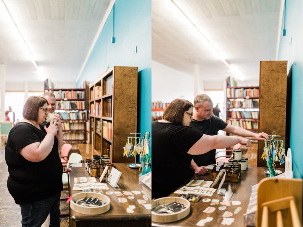Woman and man smelling candles and pointing at dreamcatchers on a merchandise shelf inside of Sundrop Books