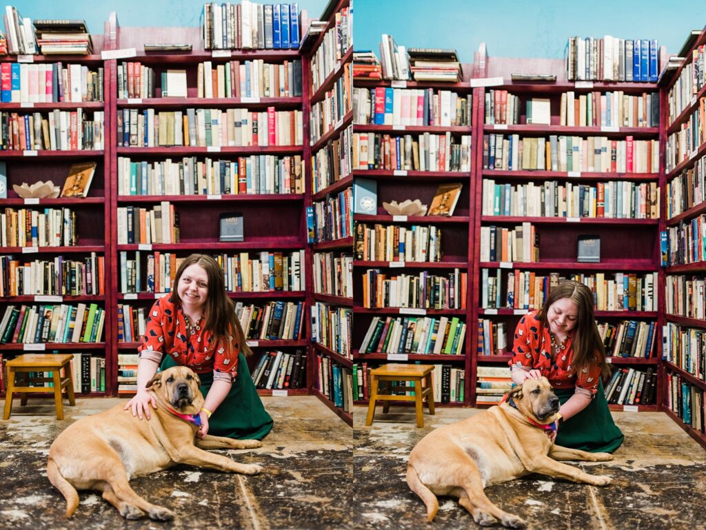 Owner of Sundrop Books on the floor with her dog smiling.