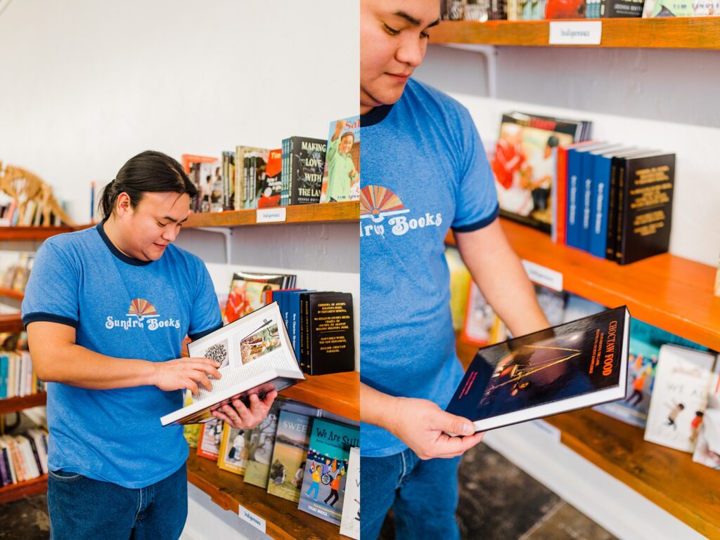 Owner (David) of Sundrop books reading one of the Indigenous books from the indigenous section inside of Sundrop Books.