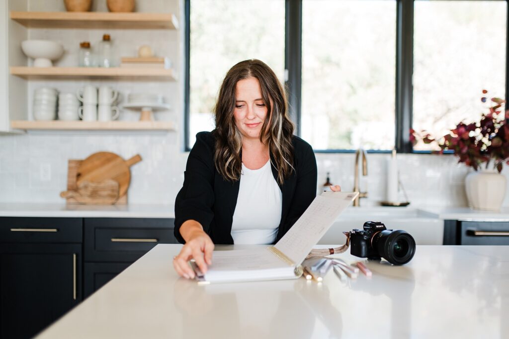 Woman opening planner at kitchen island