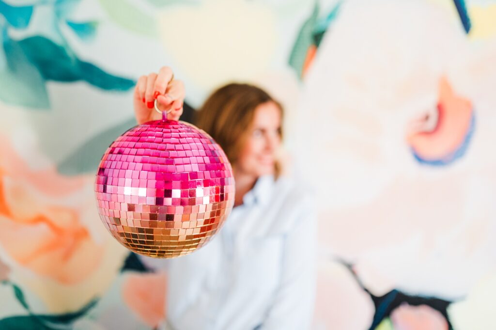 Brand photo of woman holding a pink disco ball