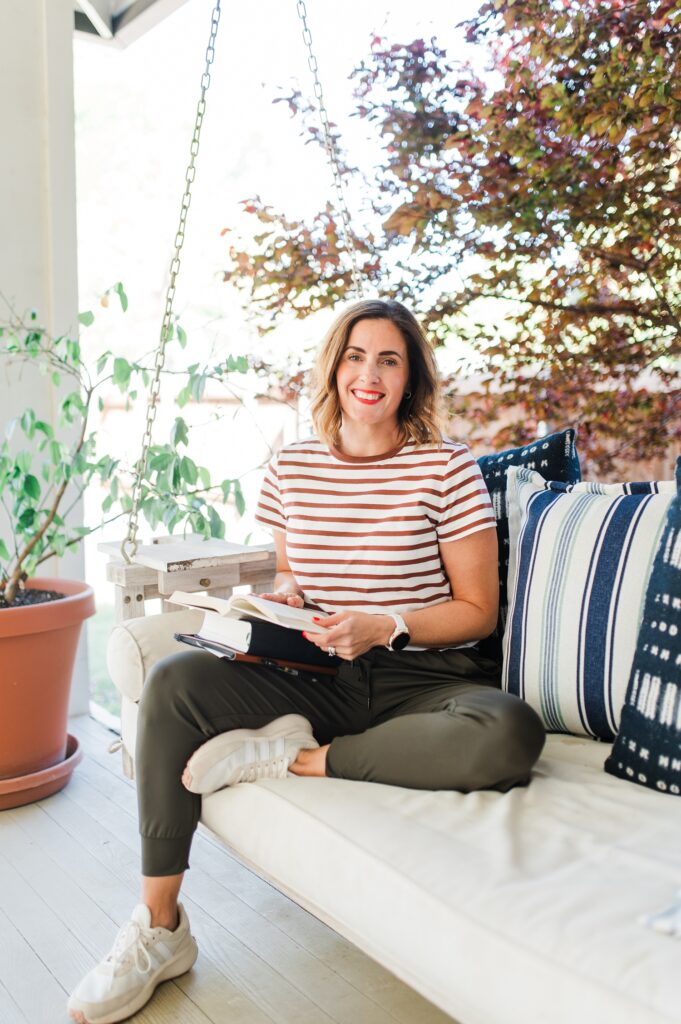 Brand photo of a photographer sitting on a porch swing journaling