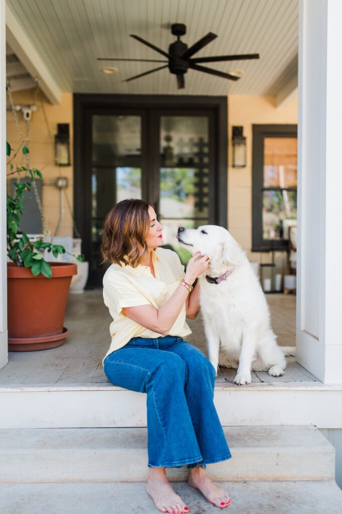 Brand photo of woman sitting on back porch with her dog