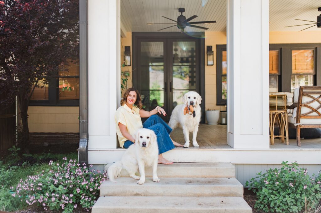 Brand photo of woman sitting on back porch with her dogs