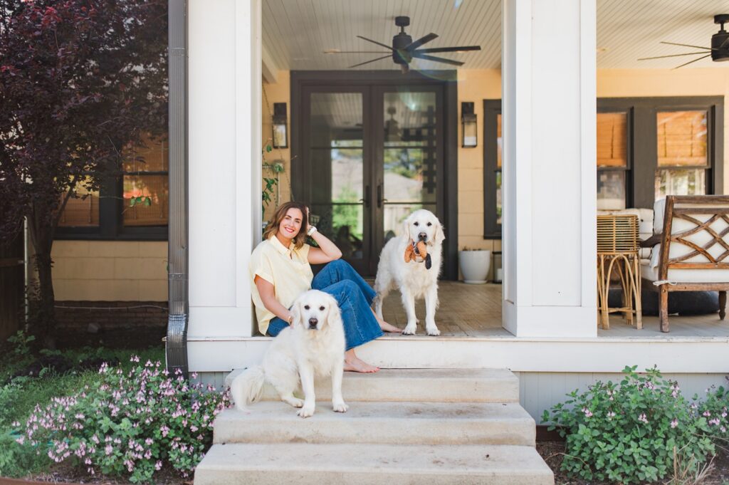 Brand photo of woman sitting on back porch with dogs