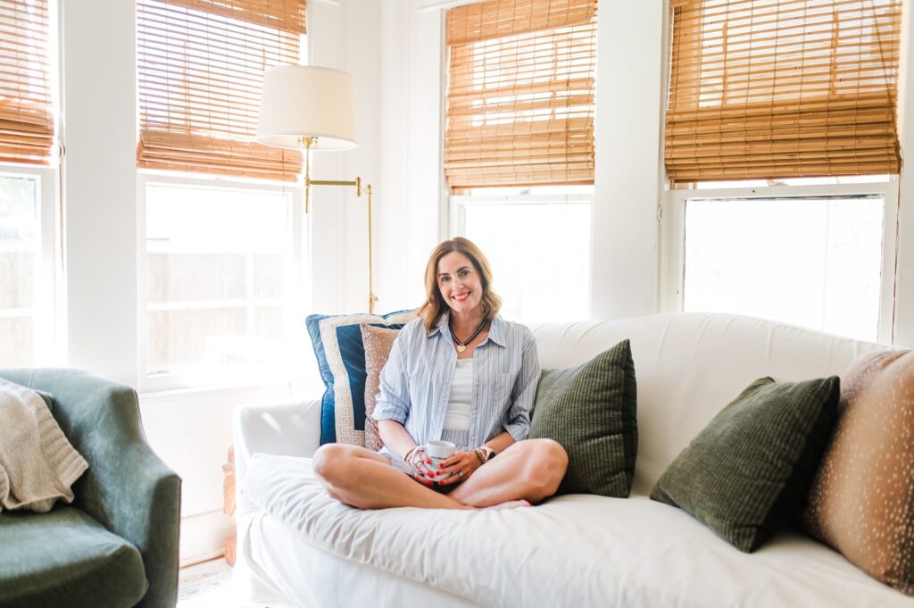 Brand photo of woman sitting on her couch drinking coffee