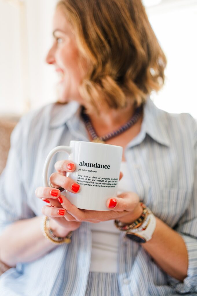 Brand photo of woman sitting on couch holding up her coffee mug