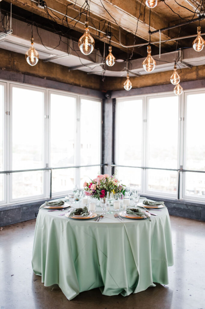 Brand photo of a green and white table setting put together by a wedding planner