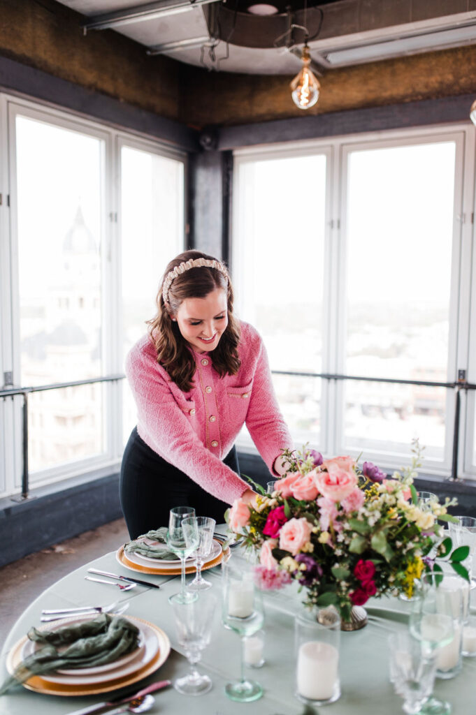 Brand photo of a wedding planner styling a green and white table setting.