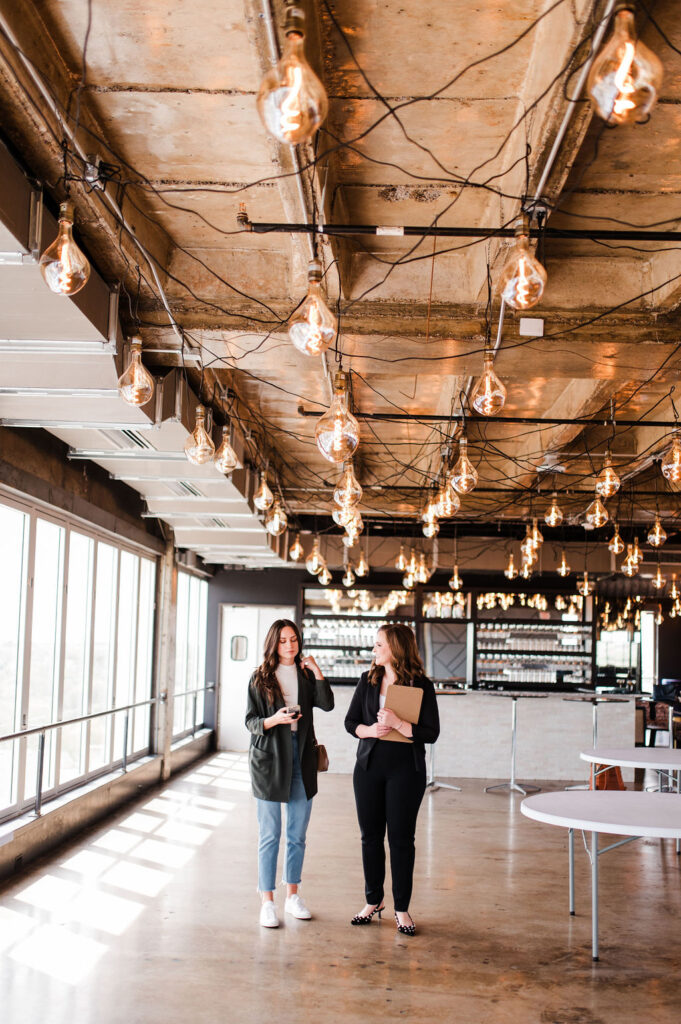 brand photo of a wedding planner walking through a venue with a potential client