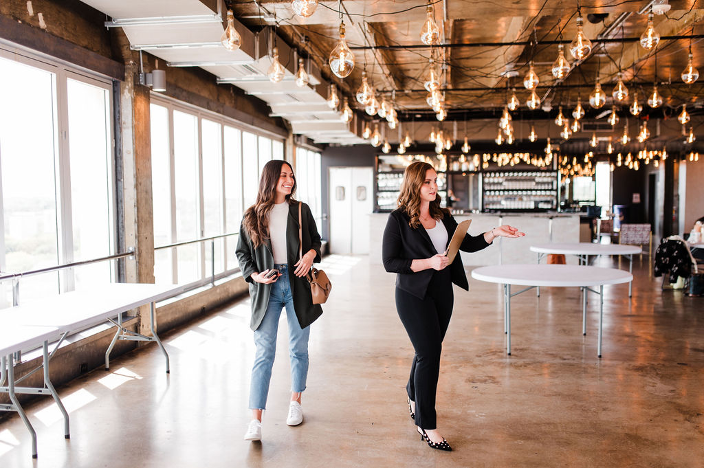 brand photo of a wedding planner walking through a venue with a potential client